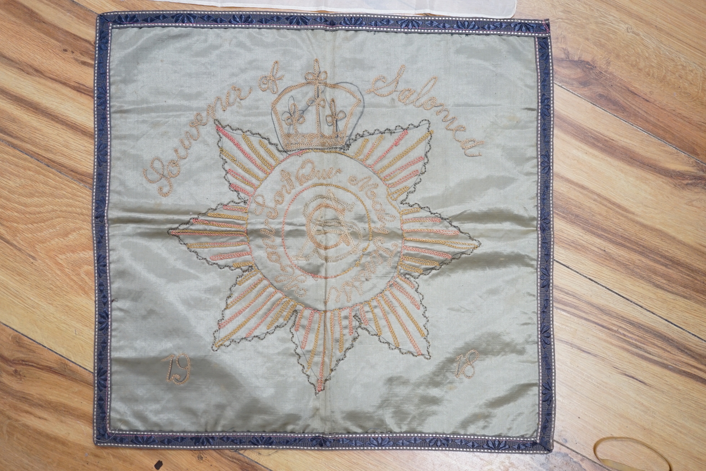 A WWII silk printed handkerchief; ‘Nippon Times’ commemorating the surrender of the Japanese, together with a WWI Army Service Corps emblem dated 1918, 44 x 45cm